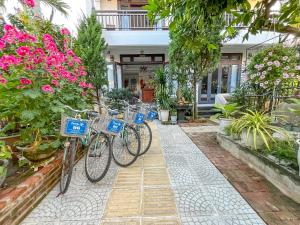 dos bicicletas estacionadas frente a una casa con flores en Trendy Life Villa, en Hoi An