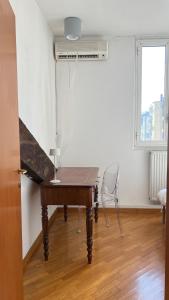 Cette chambre comprend un bureau, une fenêtre et une table. dans l'établissement Daeiouz II, à Milan