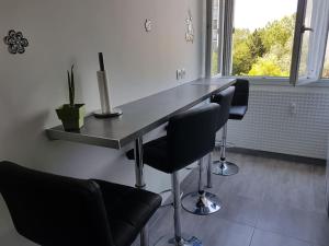 a bar with four chairs and a counter in a room at Shiny Compiègne Logement Entier in Compiègne