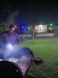 een man die 's nachts naast een grill staat bij Gill Lake Batur in Kubupenlokan