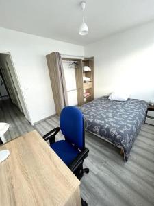 a bedroom with a blue chair and a bed at Shiny Compiègne Logement Entier in Compiègne