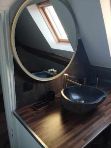 Un baño con un lavabo negro y un espejo. en La perle Dieppoise, en Dieppe
