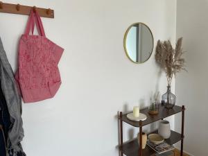 a pink bag hanging on a wall with a mirror at Chaleureux nid au cœur du village Olympique in Saint-Denis