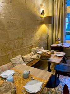 a room with tables and chairs and a brick wall at Nelli's B&B in Cospicua