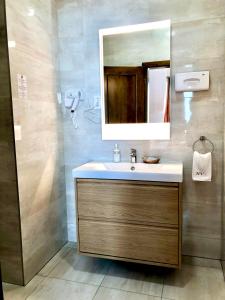 a bathroom with a sink and a mirror at Hét Vezér Apartmanhotel in Komárom