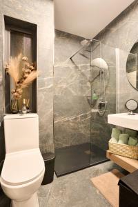 a bathroom with a toilet and a glass shower at Garden View 9 - Two Bedroom Apartment in St. Julianʼs
