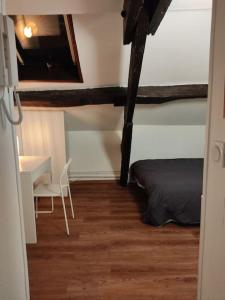 a bedroom with a bed and a desk and a table at Studio Rémois - WIFI/Netflix in Reims