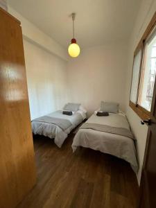 two beds in a small room with a window at La Casita de Nicolás in Mora de Rubielos