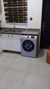a washing machine in a kitchen with a sink at Delight Bay Shortlet in Lekki