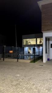 a night view of a building with a fence at Delight Bay Shortlet in Lekki