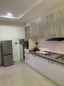 a kitchen with white cabinets and a refrigerator at Delight Bay Shortlet in Lekki