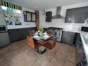 a kitchen with a table and chairs and a stove at Sirius House - sleeps 7, driveway, garden in Crewe