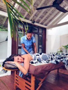 Eine Frau, die mit einem Mann auf einem Bett liegt. in der Unterkunft The White Key Luxury Villas in Gili Trawangan