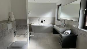 a bathroom with a tub and a sink and a toilet at Ferienhaus Alexandra in Thyrnau in Thyrnau