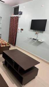 una mesa negra en una habitación con TV en la pared en Chandrika Residency, en Jhūsi