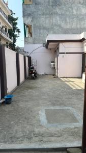 un garage avec une moto garée à côté d'un bâtiment dans l'établissement Chandrika Residency, à Jhūsi