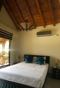 a bedroom with a white bed with blue pillows at Olon de Haciendas Olonche in Olón +39 photos