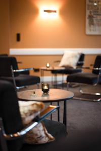 a room with chairs and a table with a candle on it at Silva Hotel Spa-Balmoral in Spa