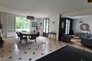 ein Wohnzimmer mit einem Tisch und einem Esszimmer in der Unterkunft Villa 35 minutes Paris in Saint-Prix