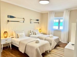 um quarto com 2 camas e uma janela em Antonio's Captain House close to beaches em Atouguia da Baleia