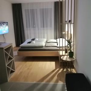 Schlafzimmer mit einem Bett, einem Tisch und einem TV in der Unterkunft Apartman 33 in Banja Luka