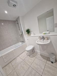 ein Bad mit einem WC, einem Waschbecken und einer Dusche in der Unterkunft Wakefield Getaway - Cosy Apt with Free Parking in Wakefield