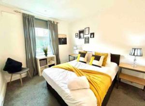 um quarto com uma cama grande e um cobertor amarelo em Meadows Court -Wyndale- Central Mansion Style 3BR em Birmingham