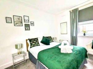 um quarto com uma cama verde e branca e um sofá em Meadows Court -Wyndale- Central Mansion Style 3BR em Birmingham