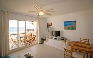 een woonkamer met een eettafel en een televisie bij Primera línea Playa Romana Frontal - Habitat ALBERT VILLAS in Alcossebre