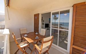 een eetkamer met een tafel en stoelen op een balkon bij Primera línea Playa Romana Frontal - Habitat ALBERT VILLAS in Alcossebre