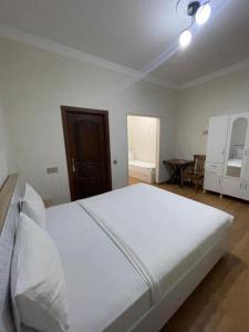 a bedroom with a large white bed and a table at Sherlock Hotel Baku in Baku