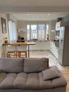 uma sala de estar com um sofá e uma cozinha em Le Faucon By Nid'Ouest em Rennes