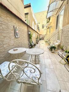 a patio with tables and chairs on a courtyard at Gloves Rooms in Naples