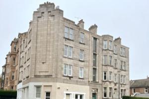 um grande edifício de tijolos com muitas janelas em Stylish & Central Flat in Edinburgh. Free Parking em Edimburgo