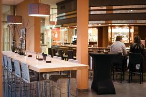 a restaurant with a long table and people sitting at tables at Silva Hotel Spa-Balmoral in Spa