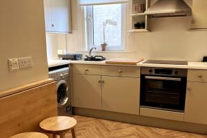 uma cozinha com um fogão e uma máquina de lavar louça em Stylish & Central Flat in Edinburgh. Free Parking em Edimburgo