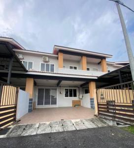 een huis met een grote oprit ervoor bij Azman Homestay in Batu Gajah