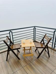dwa krzesła i stół na balkonie w obiekcie Western Ghats Holiday Home w mieście Kalpatta