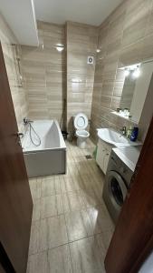 a bathroom with a tub and a toilet and a sink at Mamaia Apartments Summerland Club in Mamaia