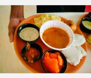 un plato de comida con diferentes tipos de comida. en Stayz Inn Hotels - The Gate Way Of Madras - Near Chennai Central Railway Station en Chennai