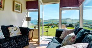 a living room with a couch and a large window at 18 Ard na Mara in Dingle +11 photos