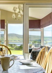 a dining room with a table and chairs with a view at 18 Ard na Mara in Dingle