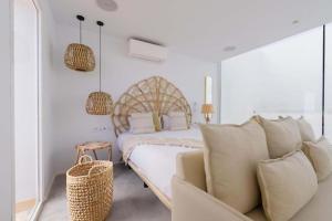 Un dormitorio blanco con una cama y un sofá. en Alma Suite Duplex, en Caleta de Sebo