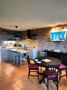 een keuken met een tafel en stoelen en een televisie bij Apartment Walpurgis mit toller Aussicht & Schwimmbad in Hohegeiß