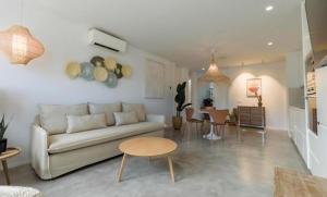 塞博河畔卡莱塔Alma Suite Duplex的客厅里有一张沙发和一张桌子。