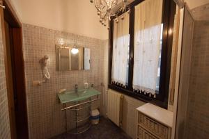 baño con lavabo verde y ventana en Antica Corte Milanese, en Novate Milanese