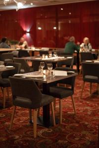 een eetkamer met tafels en stoelen met mensen op de achtergrond bij Silva Hotel Spa-Balmoral in Spa