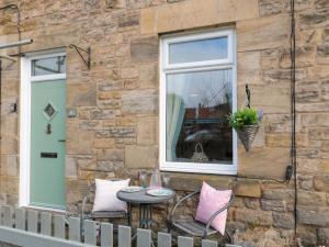 a patio with a table and a window at Cosy Cottage in Morpeth
