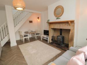 a living room with a fireplace and a dining room at Cosy Cottage in Morpeth