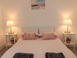 ein Schlafzimmer mit einem großen weißen Bett mit zwei Lampen in der Unterkunft Cosy Cottage in Morpeth